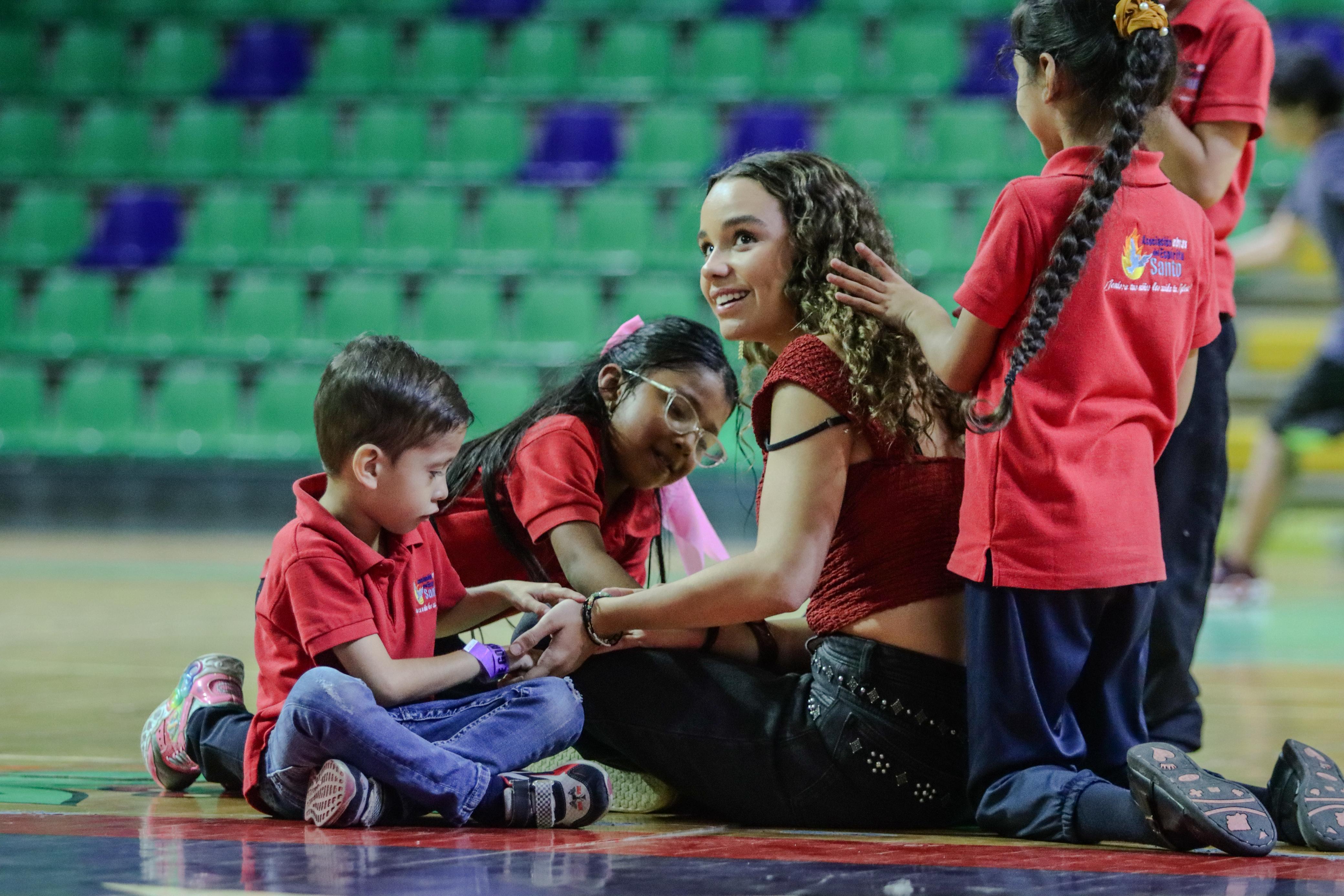Voluntaria conectando con los más pequeños en el suelo de la cancha