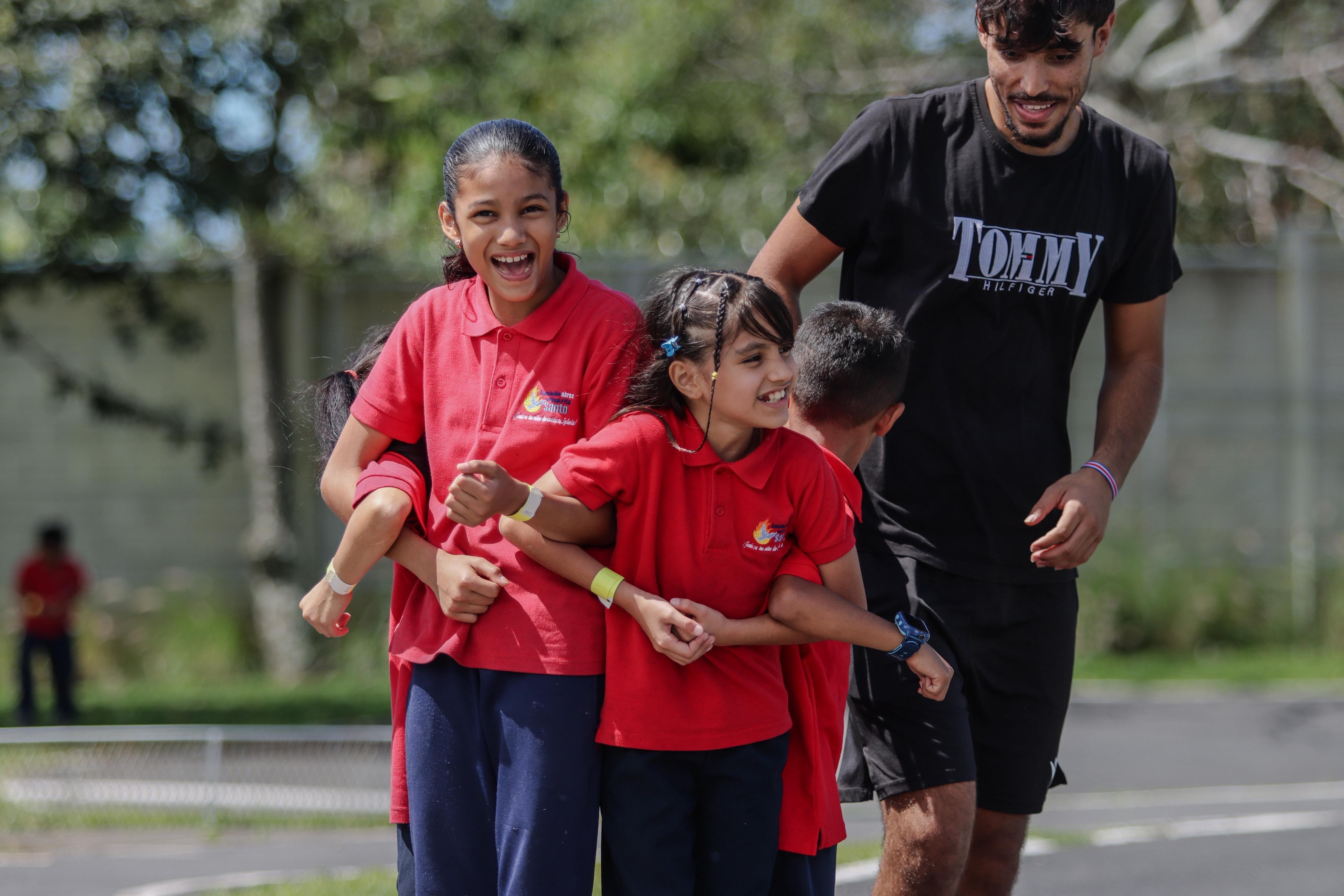 Niñas y mentor corriendo juntos durante las actividades al aire libre